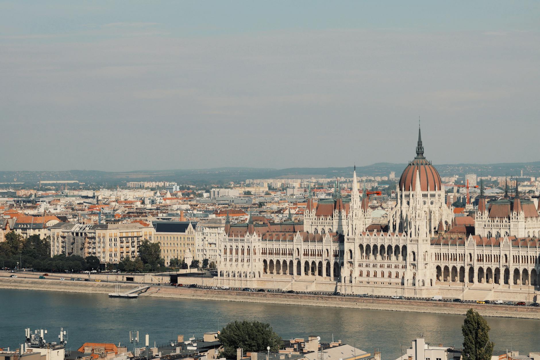 Weekend w Budapeszcie: najpiękniejsze widoki, termy i atrakcje za niewielkie pieniądze Parlament w Budapeszcie nad Dunajem oświetlony wieczornym światłem