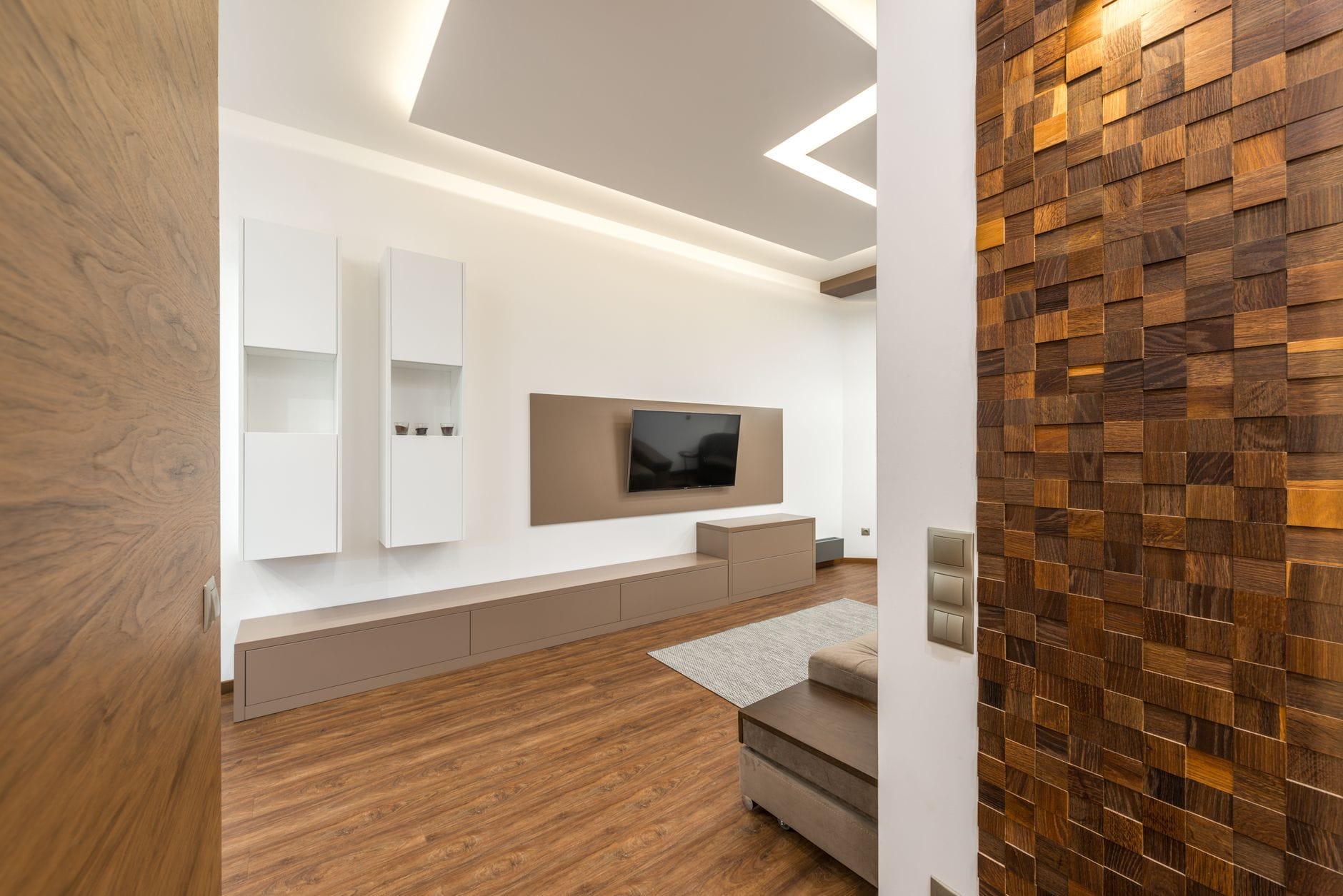 Nowoczesny salon z telewizorem w drewnianej zabudowie wnęki