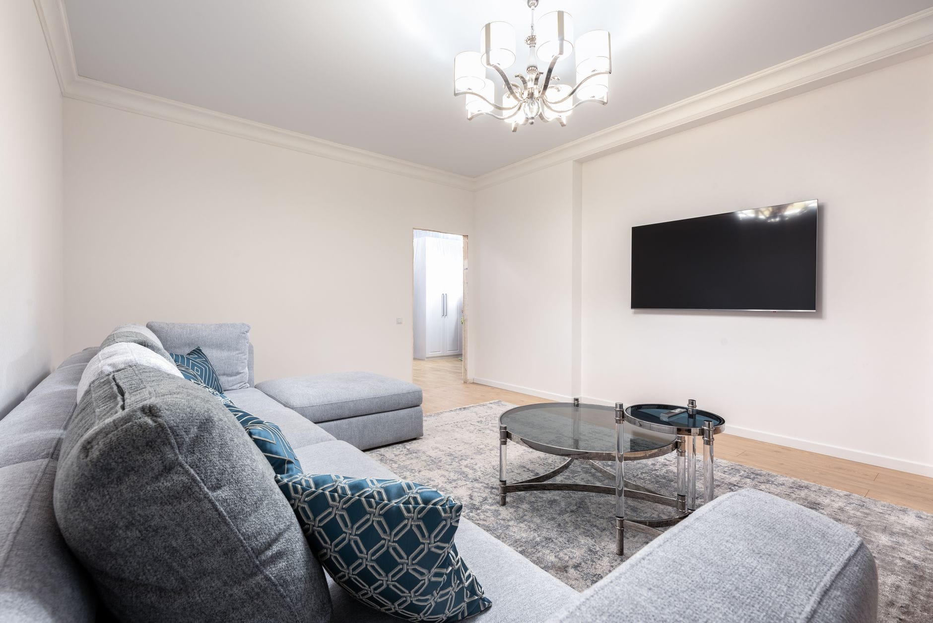 Nowoczesny salon z zabudową wnęki pod telewizor i sofą
