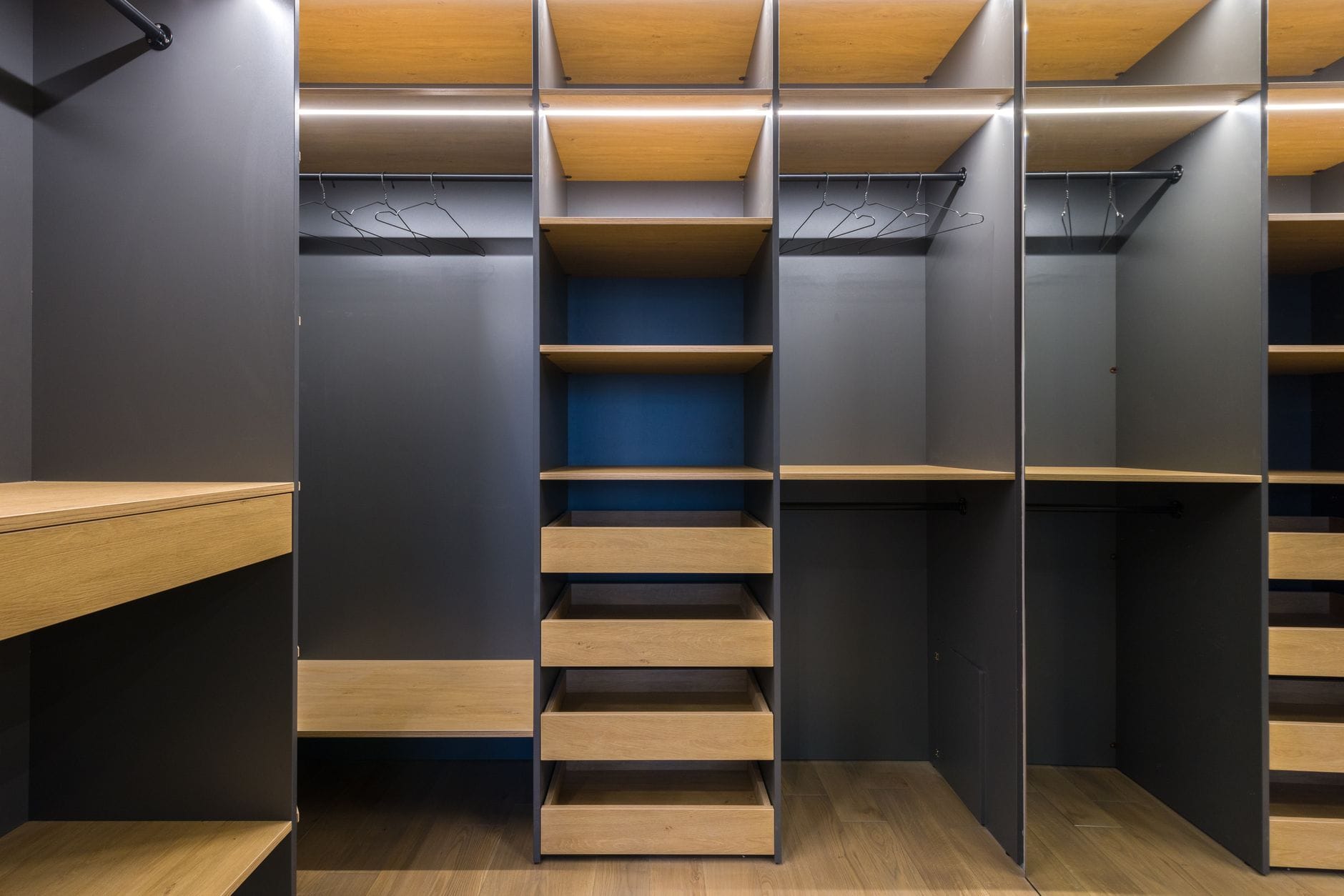 Szafy wnękowe w mieszkaniach deweloperskich: jak poprawić układ i uniknąć pustych przestrzeni Nowoczesna garderoba z drewnianymi półkami i zabudową do przechowywania
